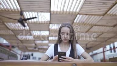 美丽的年轻女子在咖啡馆里使用现代智能<strong>手机</strong>，在<strong>手机</strong>上<strong>输入</strong>短信